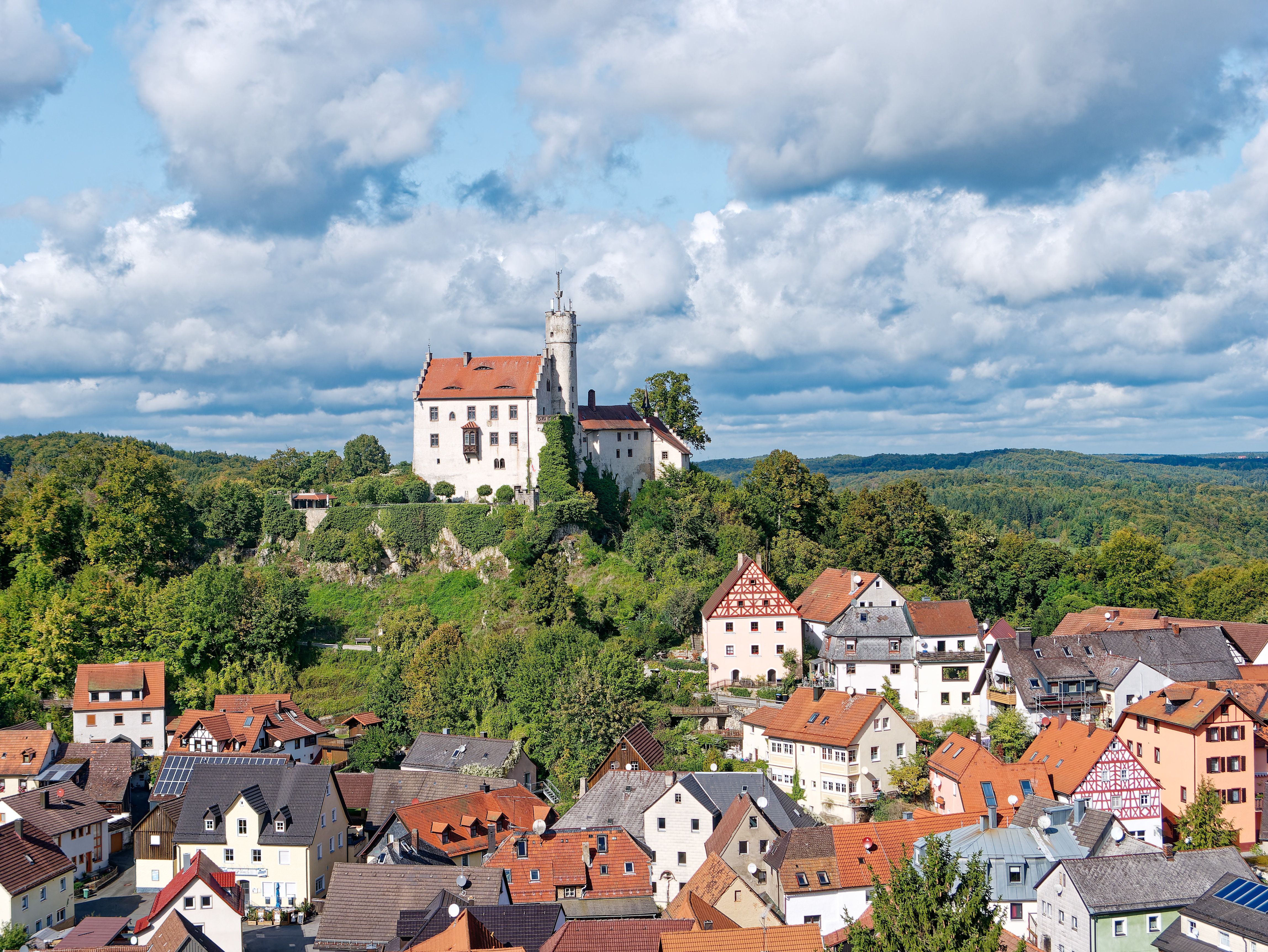 Aerial view of Gößweinstein Castle and its historic Bavarian town surrounded by green countryside.
